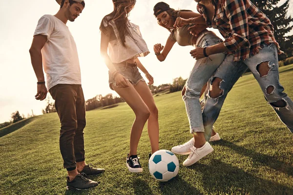 Друзі в повсякденному одязі грають у футбол — стокове фото