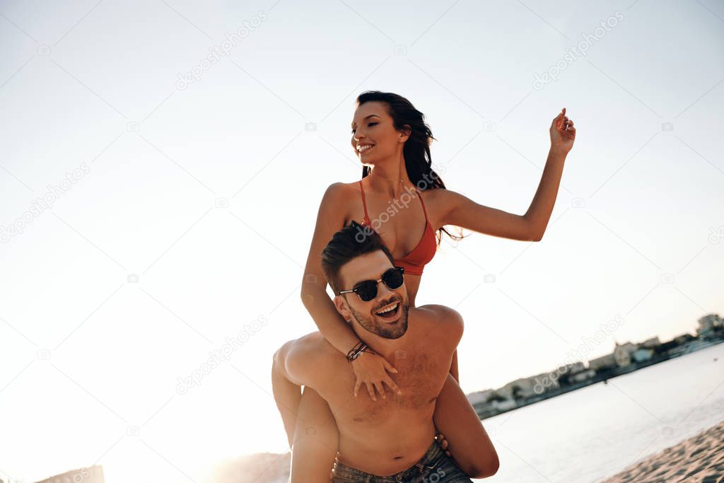 man carrying on shoulders his girlfriend