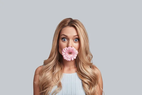 Frau bedeckt Mund mit Blume — Stockfoto