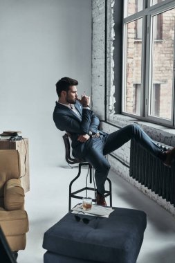 tam takım taburede oturan adam 