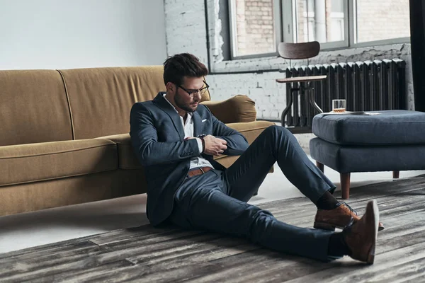 Mannen i full kostym som sitter på golvet — Stockfoto