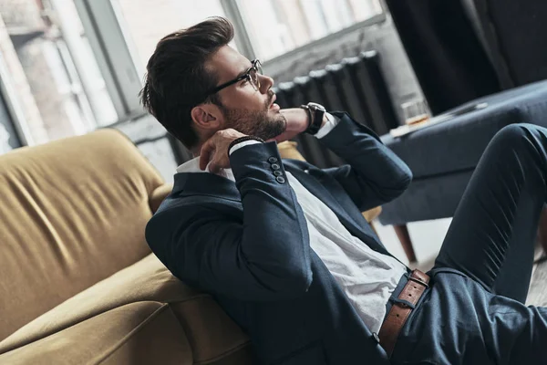 Man in volledige pak zittend op de vloer — Stockfoto