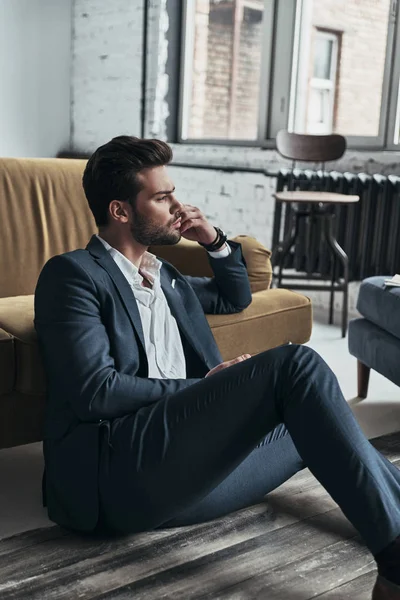 Man in full suit sitting on floor — Stock Photo, Image