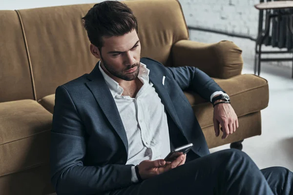 Hombre en traje completo sentado en el suelo — Foto de Stock