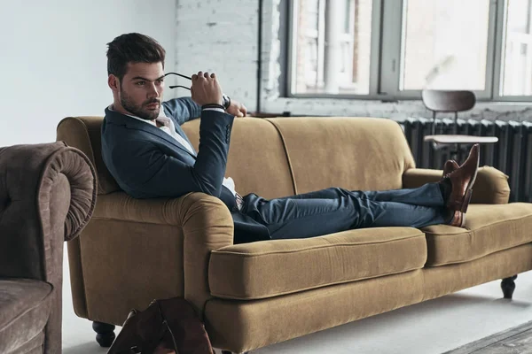 Businessman relaxing on sofa — Stockfoto