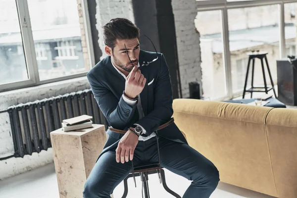 Man in full suit sitting on stool — Stock Photo, Image