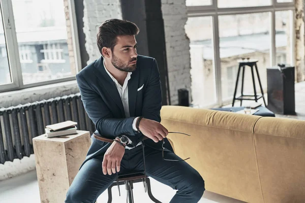 Man in full suit sitting on stool — Stock Photo, Image