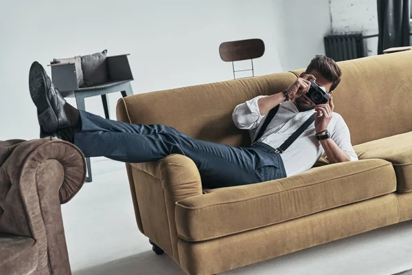 Φωτογράφος man χαλαρώνοντας στον καναπέ — Φωτογραφία Αρχείου