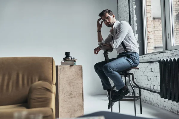 Young man sitting on stool — Stock Photo, Image