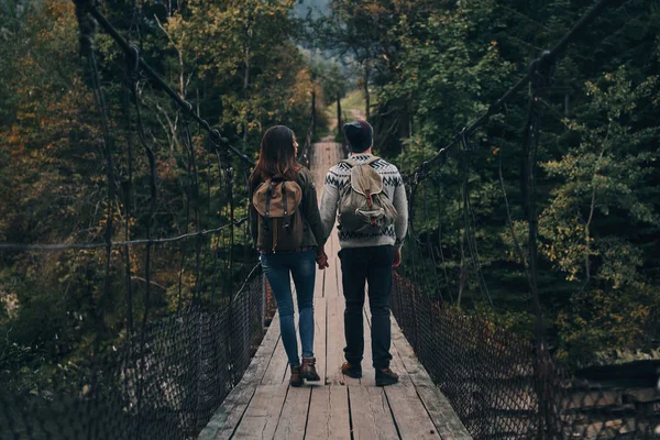 Пара ходит по подвесному мосту — стоковое фото