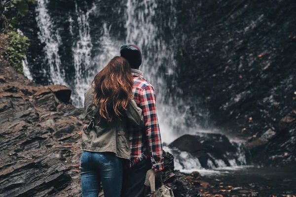 Paar verliefd omarmen in de buurt van de waterval — Stockfoto