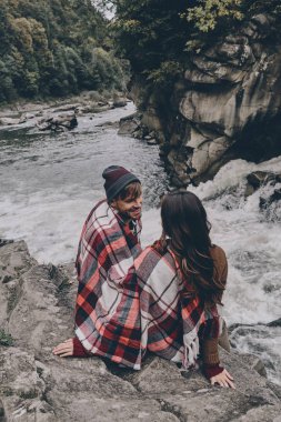 kayalar üzerine oturan battaniye ile kaplı Çift