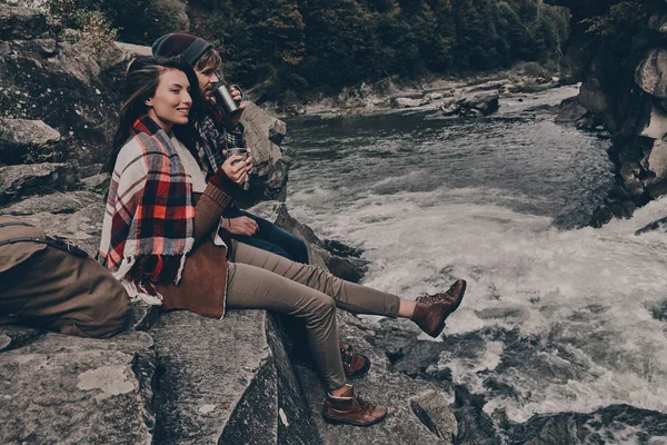 Paar mit Decke bedeckt auf Felsen sitzend — Stockfoto