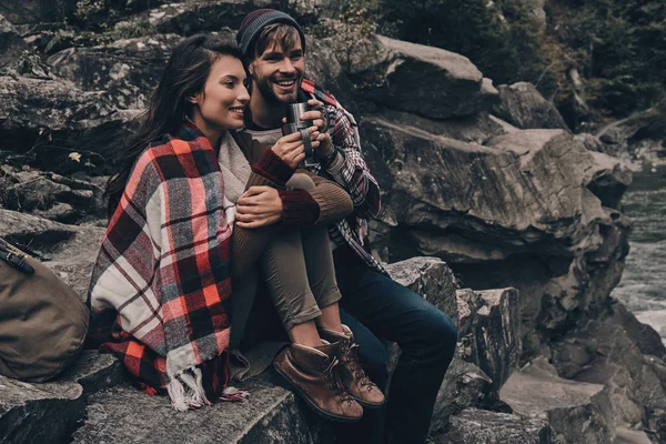 Pár zakrýt dekou sedící na skále — Stock fotografie