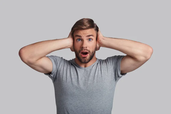 Shocked young man covering ears — Stock Photo, Image