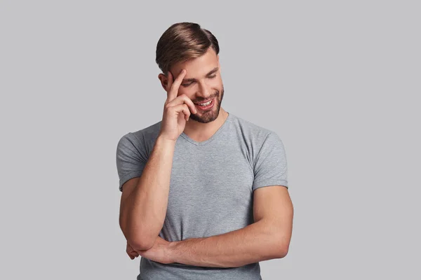 Uomo sorridente e toccante la testa — Foto Stock