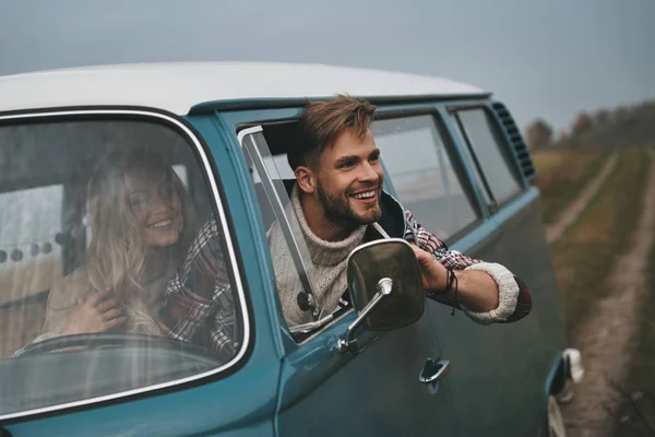 beautiful young couple in love enjoying travel in vintage car, man looking out the window