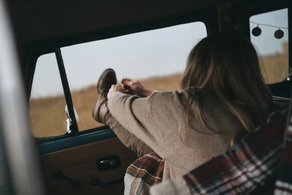 女性が車に坐っている間靴ひもを結ぶ — ストック写真