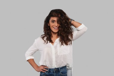 Studio poz ve kıvırcık saçları dokunmadan oynak esmer kadın