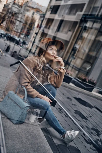 Reflexão Vidro Mulher Loira Bonita Chapéu Sentado Rua Cidade Segurando — Fotografia de Stock