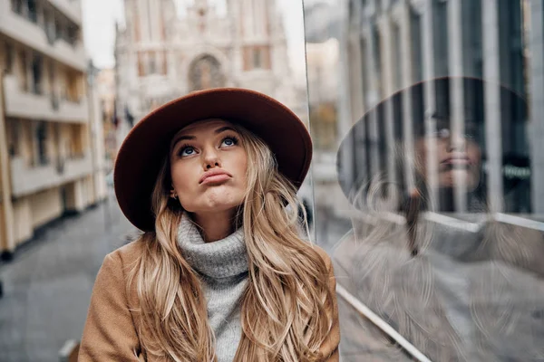 都市の通り変な顔を作る帽子の豪華なブロンドの女性 — ストック写真