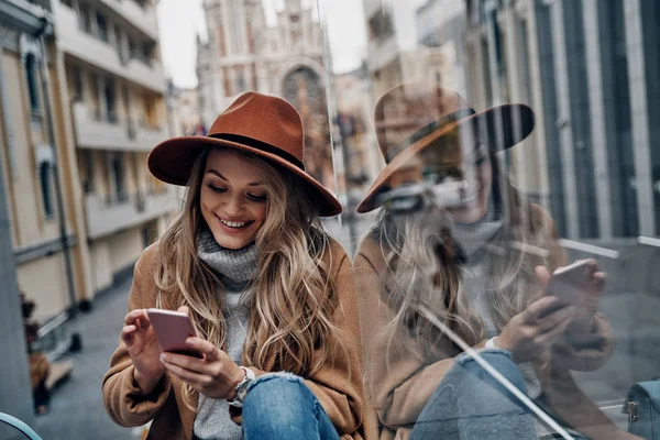 Vonzó Szőke Fiatal Segítségével Okos Telefon Ülve Szabadban — Stock Fotó