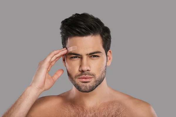 Shirtless Unhappy Brunette Man Touching Adhesive Bandage His Forehead — Stock Photo, Image