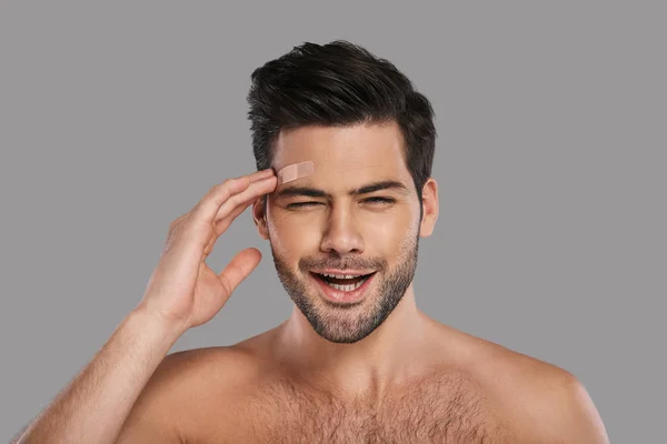 Shirtless Unhappy Brunette Man Touching Adhesive Bandage His Forehead — Stock Photo, Image