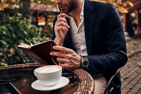 Hombre Negocios Celebración Diario Pluma Mesa Con Taza Capuchino Aromático —  Fotos de Stock