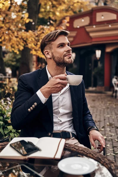 Bonito Homem Negócios Segurando Xícara Café Enquanto Sentado Restaurante Livre — Fotografia de Stock