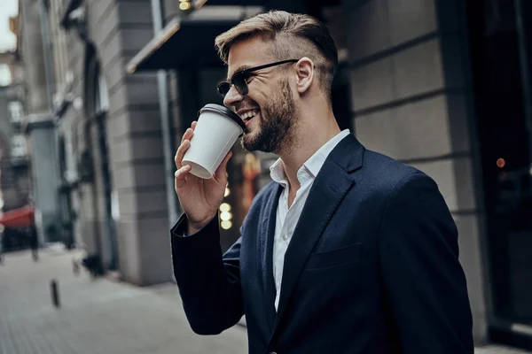 Uśmiechający Się Przystojny Biznesmen Picia Kawy Stojąc Zewnątrz — Zdjęcie stockowe