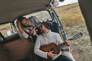 adam sevgilisini retro tarzı mini van araba için akustik gitar yeni şarkı oynamak