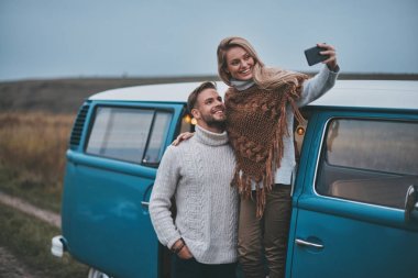 Selfie alma ve onların yol seyahat tadını çıkarırken gülümseyen güzel genç Çift