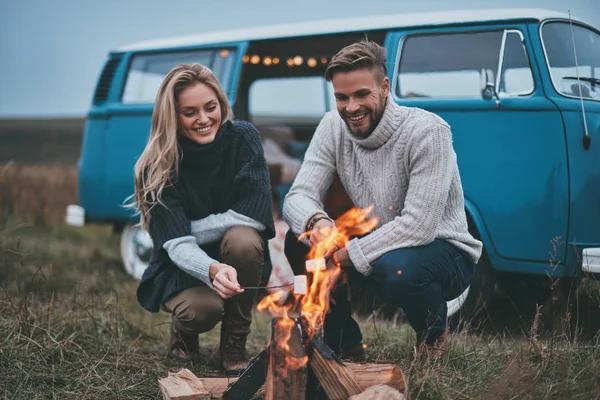 美丽的年轻夫妇在篝火上烤棉花糖 — 图库照片