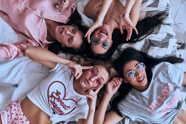 Ovanifrån Fyra Vackra Unga Kvinnor Ler Liggande Sängen Pyjamas — Stockfoto