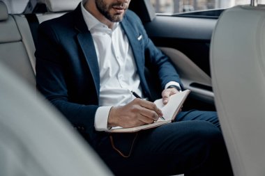 Gencin resmi aşınmaya arabanın içinde otururken günlüğüne notlar yazma yakın çekim