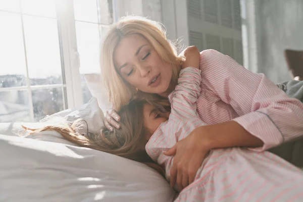 Jovem Mãe Bonita Com Filhinha Fofa Abraçando Sorrindo Enquanto Deitada — Fotografia de Stock