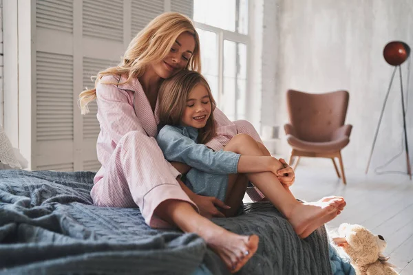 Mooie Blonde Moeder Haar Dochter Omarmen Glimlachen Terwijl Zittend Bed — Stockfoto