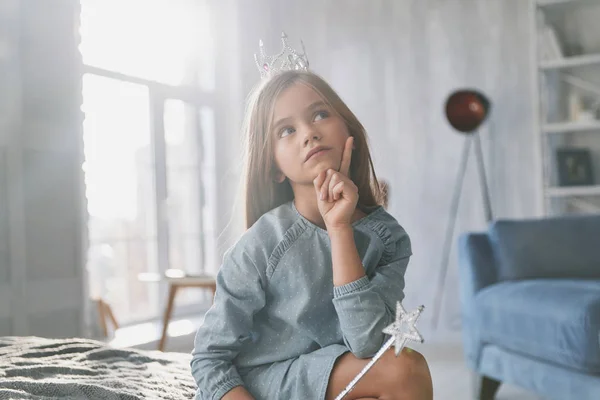 Linda Niña Manteniendo Mano Barbilla Mirando Hacia Otro Lado Mientras —  Fotos de Stock