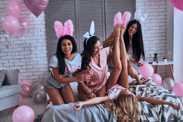 Lekfulla Unga Kvinnor Bunny Earsand Pyjamas Leende Medan Sitter Sängen — Stockfoto