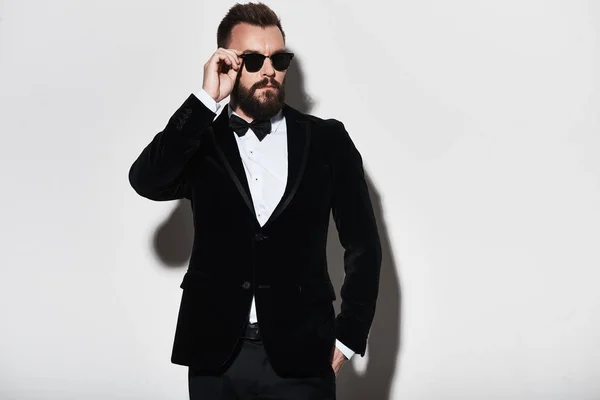 Hombre Guapo Traje Ajustando Sus Gafas Mientras Está Pie Sobre —  Fotos de Stock