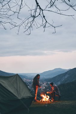 Dağda kamp kamp ateşi ile ısınma kadar güzel genç Çift