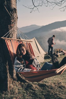 battaniye ile örtülü ve hamak, arka plan üzerinde duran erkek rahatlatıcı kadın 