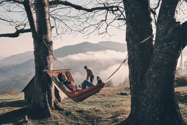 自然の美を楽しむ彼氏ながらハンモックに横たわる女秋山でキャンプ — ストック写真