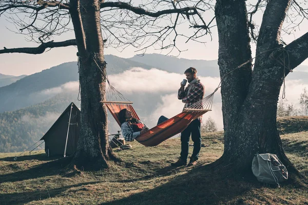 Mulher Descansando Rede Nas Montanhas Enquanto Homem Bonito Falando Com — Fotografia de Stock