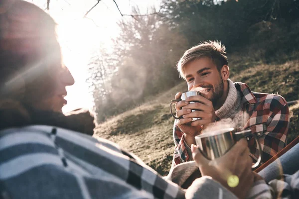 朝の山でキャンプしながらコーヒーを持っている幸せな若いカップル — ストック写真