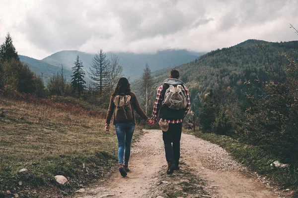 在山上行走的情侣背包的后视图旅游目的地 — 图库照片