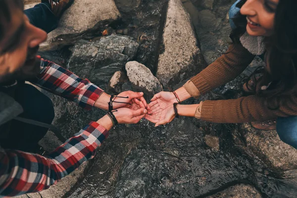 山でハイキングしながら川で手を洗う若いカップルのクローズ アップ — ストック写真