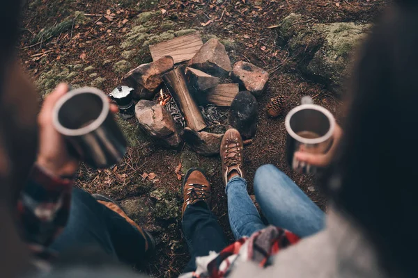ホットド リンクのカップとキャンプファイヤーの近く地球温暖化の人々 のトップ ビュー — ストック写真