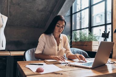 Onun atölyesinde otururken skeçler çalışan güzel genç kadın
